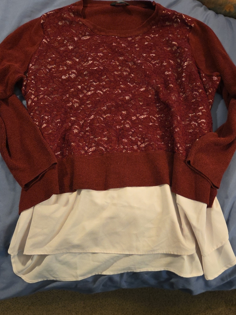 A Red Sweater With A White Undershirt Attached